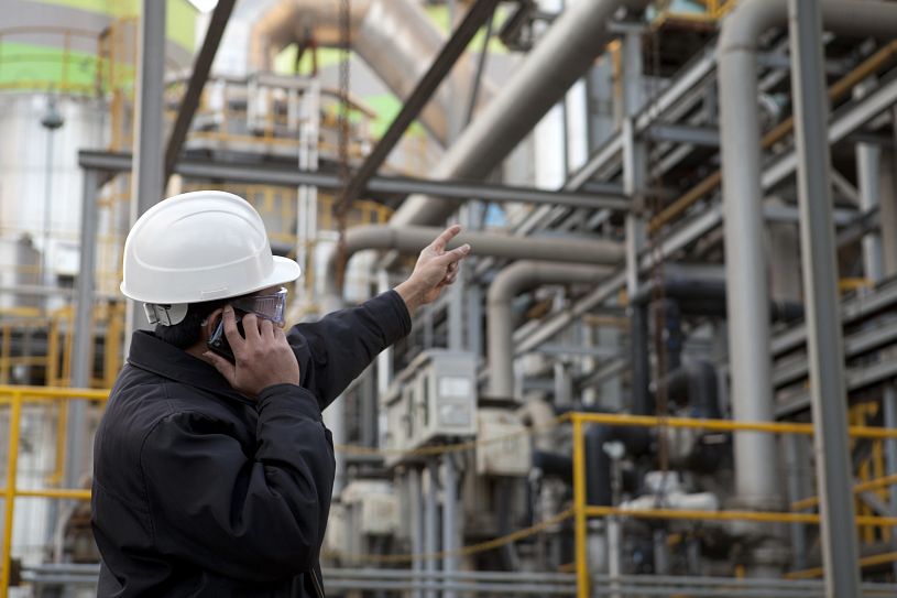 man in hard hat on phone looking at equipment