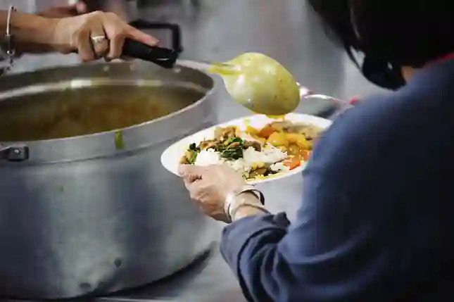 una mujer a la que se le sirve un plato de comida