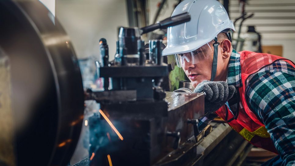 man working on equipment with hard hat